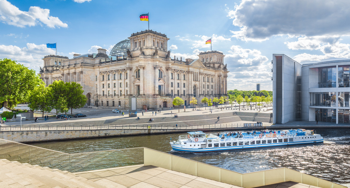 Berlin government district with Reichstag and ship on Spree river in summer, Berlin Mitte, Germany