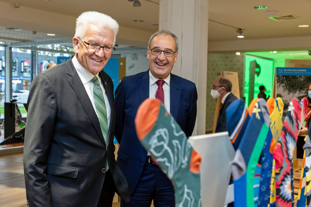 Ministerpräsident Winfried Kretschmann (links) und der Schweizer Bundespräsident Guy Parmelin (rechts) besuchen die Ausstellung im Pop-up House of Switzerland in Stuttgart.