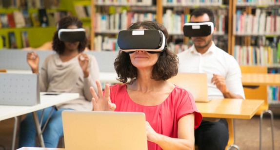Eine Gruppe von Studierenden nutzt VR-Simulatoren während des Unterrichts.