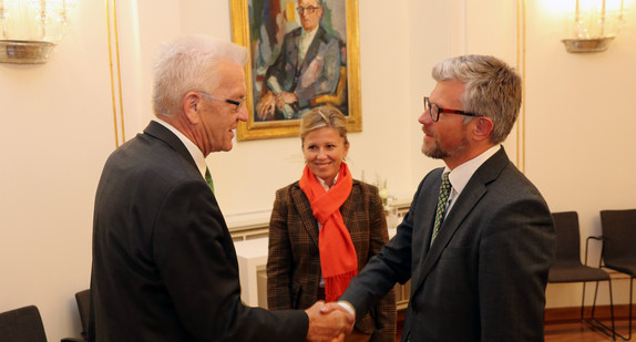 Ministerpräsident Winfried Kretschmann (l.) begrüßt den ukrainischen Botschafter Andrij Melnyk (r.) und dessen Ehefrau (M.)