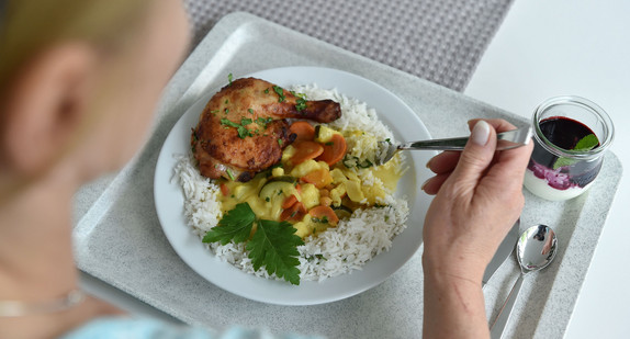 Eine Frau isst in einer Kantine zum Mittag. (Foto: © dpa)