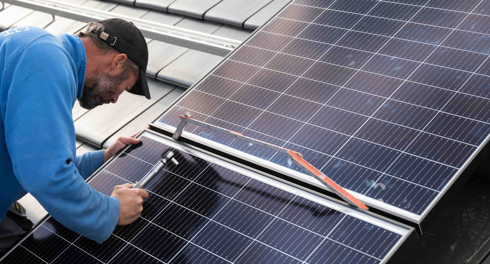 Handwerker montiert Photovoltaik-Anlage