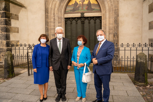 v.l.n.r: Gabriele Haseloff, Ministerpräsident Winfried Kretschmann mit Ehefrau Gerlinde und Reiner Haseloff, Ministerpräsident von Sachsen-Anhalt, vor der Thesentür von Martin Luther am Eingang zur Schlosskirche in Wittenberg (Bild: Staatsministerium Baden-Württemberg)