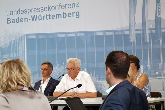 Ministerpräsident Winfried Kretschmann (M.) und Regierungssprecher Rudi Hoogvliet (l.)