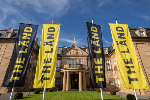 Vier Fahnen mit der Aufschrift „THE LÄND“ vor der Villa Reitzenstein in Stuttgart