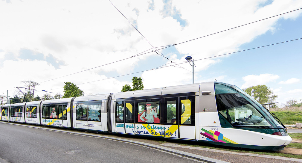 Ein Straßenbahnzug zwischen dem deutschen Kehl und dem französischen Straßbourg mit Werbung für ein grenzüberschreitendes Fachkräfteprogramm.