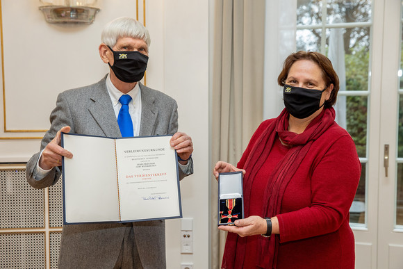 Staatsministerin Schopper (r.) überreicht Prof. Gert Weisskirchen (l.) den Verdienstorden der Bunderepublik