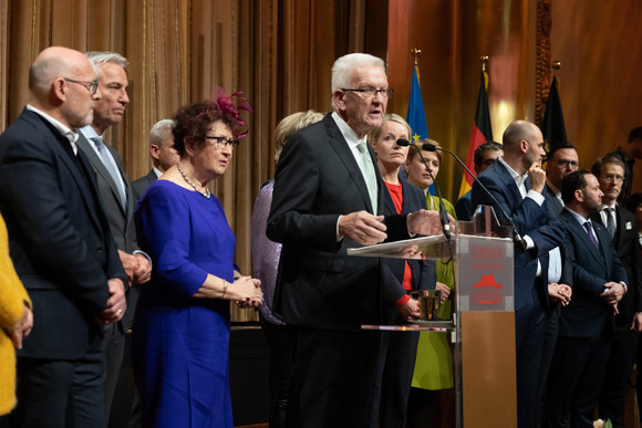 Ministerpräsident Winfried Kretschmann (Mitte) bei seiner Ansprache, neben ihm seine Ehefrau Gerlinde und Mitglieder der Landesregierung.