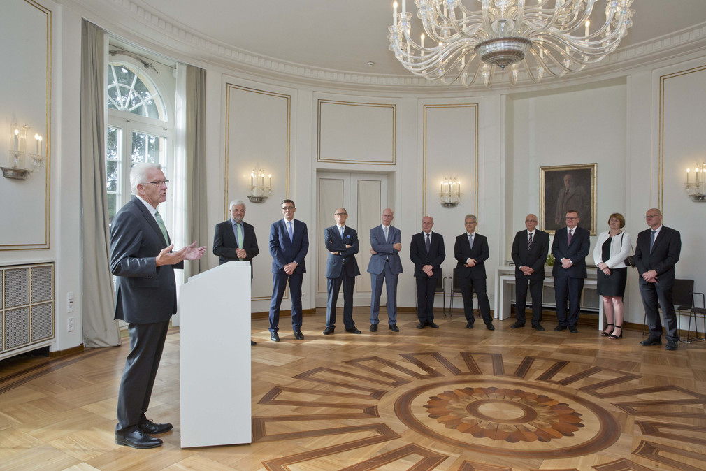 Ministerpräsident Winfried Kretschmann (l.) spricht zu den Präsidentinnen und Präsidenten der Obersten Gerichtshöfe des Bundes
