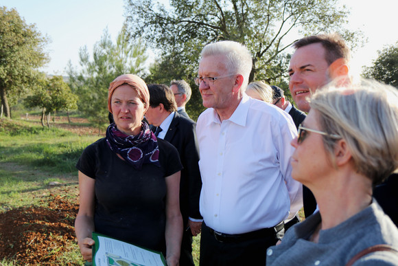 Ministerpräsident Winfried Kretschmann (M.) beim Besuch der Begegnungsstätte Tent of Nations