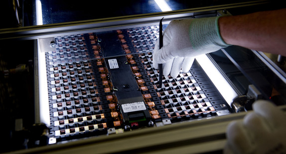 Ein Mitarbeiter arbeitet in der Produktion an einer Zelle für eine Elektroauto-Batterie. (Bild: dpa)