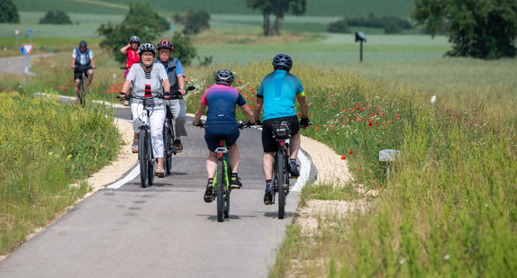 Radfahrer sind auf einem Radweg unterwegs.