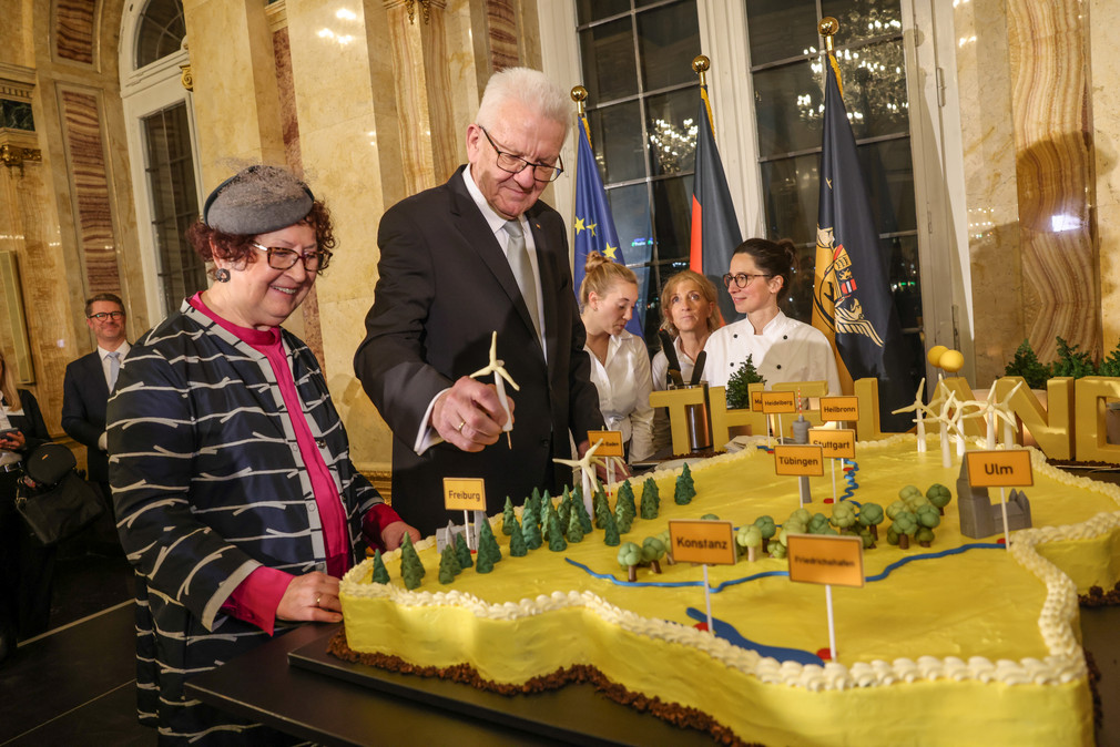 Ministerpräsident Winfried Kretschmann (rechts) und seine Ehefrau Gerlinde (links) stehen neben einer großen Baden-Württemberg-Torte.
