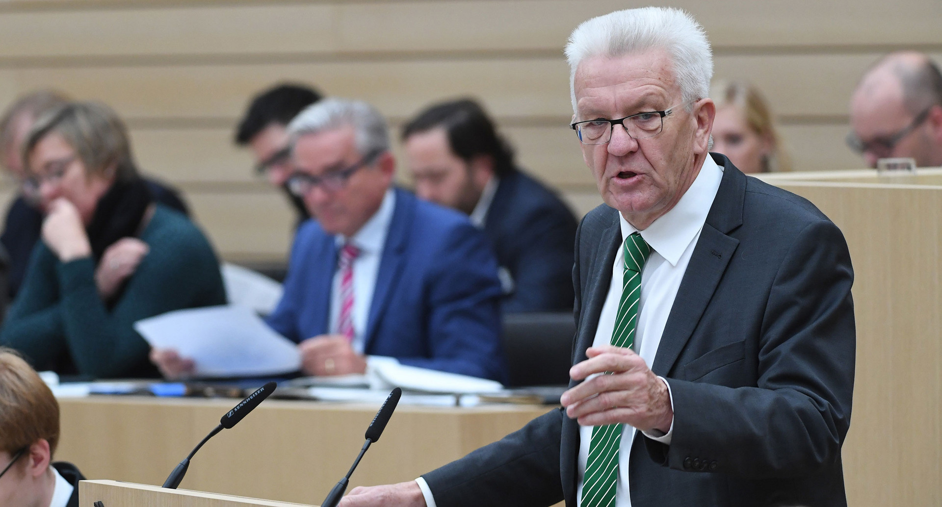 Kretschmann steht am Rednerpult im sanierten Landtag von Baden-Württemberg (Bild © dpa).