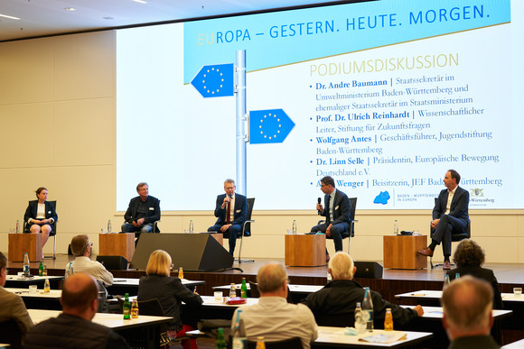 Auf einer Bühne diskutieren die Beteiligten der Podiumsdiskussion der Festveranstaltung „EUropa – Gestern. Heute. Morgen.“