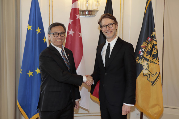 Internationales Stegmann empfängt Botschafter von Singapur Staatsminister Dr. Florian Stegmann (rechts) und der Botschafter der Republik Singapur, Lee Chong Hock (links) stehen vor Fahnen und geben sich die Hand.