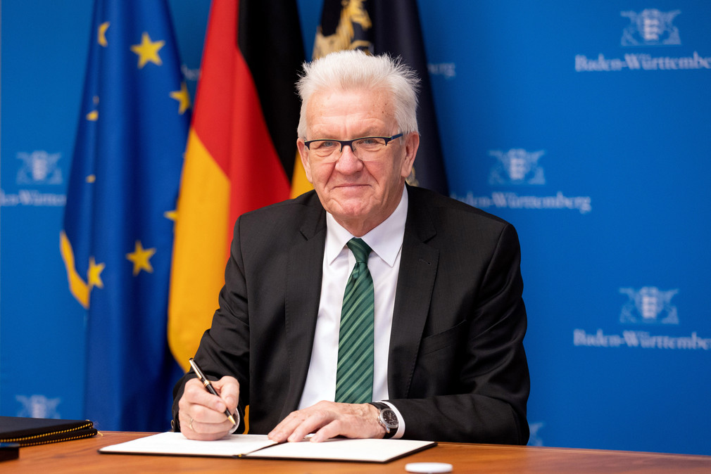 Ministerpräsident Winfried Kretschmann (l.) bei der Vertragsunterzeichnung