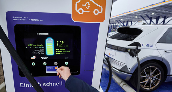 Ein Elektroauto wird an einer Schnellladestation aufgeladen. Auf dem Display kann man den aktuellen Ladestand und andere Ladedaten ablesen.