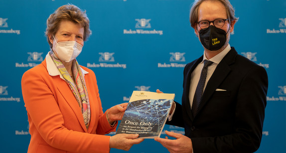 Die Vorsitzende des Normenkontrollrats Baden-Württemberg, Dr. Gisela Meister-Scheufelen (l.), überreicht dem Staatsminister und Chef der Staatskanzlei, Dr. Florian Stegmann (r.), in der Villa Reitzenstein in Stuttgart den Empfehlungsbericht zu Once Only.