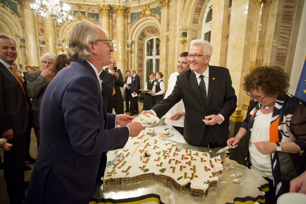 Ministerpräsident Winfried Kretschmann (2.v.r.) verteilt Tortenstücke an die Gäste