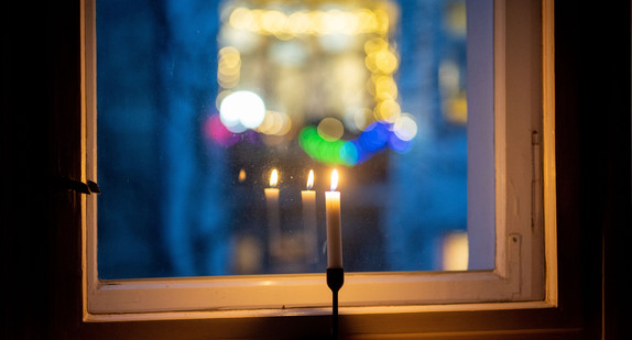 Eine Kerze brennt in einem Fenster als Zeichen des gemeinsamen Gedenkens im Rahmen der Aktion "#lichtfenster" für die Toten im Zusammenhang mit der Corona-Pandemie.