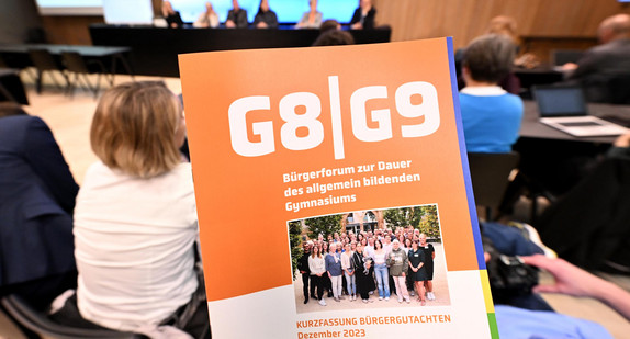 Eine Abbildung des Deckblatts der Kurzfassung des Bürgergutachtens zur Dauer des allgemein bildenden Gymnasiums während der Vorstellung in der Landespressekonferenz.