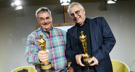 Gerd Nefzer und Staatssekretär Arne Braun halten zwei Oscars in den Händen
