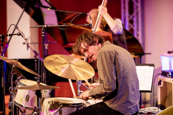 Großaufnhame von Schlagzueger Lucas Zibulski gebeugt an den Drums.