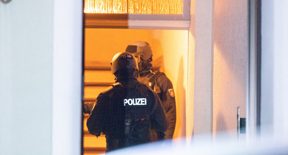 Ein Polizist trägt beim Einsatz einen hydraulischen Türöffner.