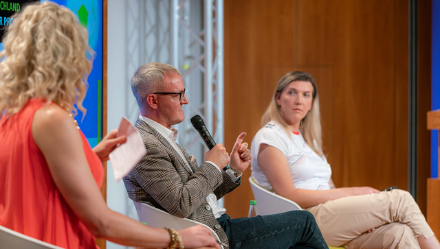 (v.l.n.r.) Moderatorin Jurassica Parka, Alexander Wehrle und Julia Monro auf dem Podium im Gro&szlig;en Saal
